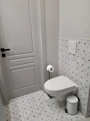 a white bathroom with a toilet and a door at Hill Top apartment in central Kedainiai in Kėdainiai