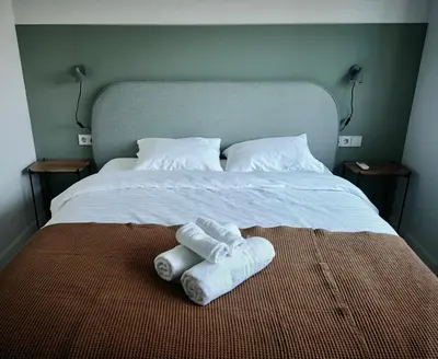 a bed with two towels and two pillows on it at Hill Top apartment in central Kedainiai in Kėdainiai