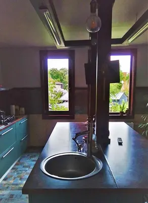 a kitchen counter with a sink and two windows at Quiet place in Kaunas