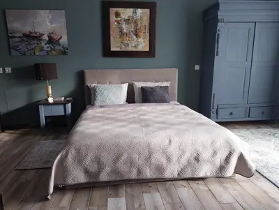 a bedroom with a bed with a white comforter at Quiet place in Kaunas