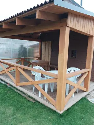 a pavilion with chairs and a table on a deck at Užupio namai in Anykščiai
