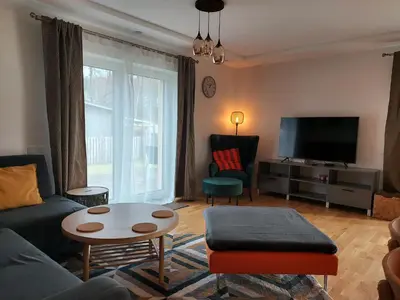 a living room with a couch and a table and a tv at Gelvadiskes Forest in Vilnius