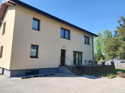 a white house with black windows and stairs at Gelvadiskes Forest in Vilnius