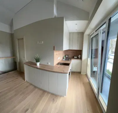 a kitchen with a island in the middle of a room at Apartamentai Muziejaus g. in Birštonas