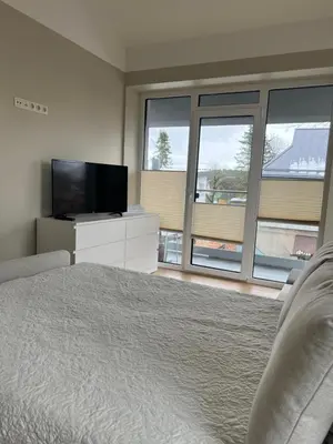 a bedroom with a bed and a flat screen tv at Apartamentai Muziejaus g. in Birštonas