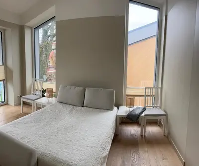 a bedroom with a bed and a large window at Apartamentai Muziejaus g. in Birštonas