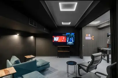 a living room with a tv and a couch and chairs at Youston self check-in coliving Vilnius in Vilnius