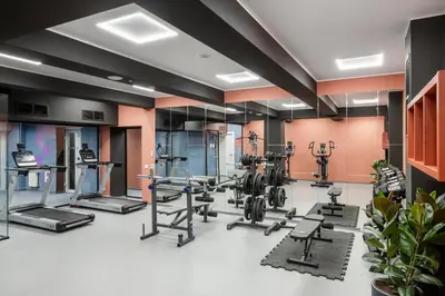 a gym with several treadmills and elliptical machines at Youston self check-in coliving Vilnius in Vilnius