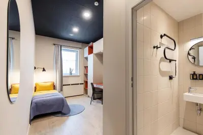 a bedroom with a bed and a bathroom at Youston self check-in coliving Vilnius in Vilnius