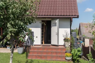 a house with a red roof and white doors at Dvi liepos in Merkinė