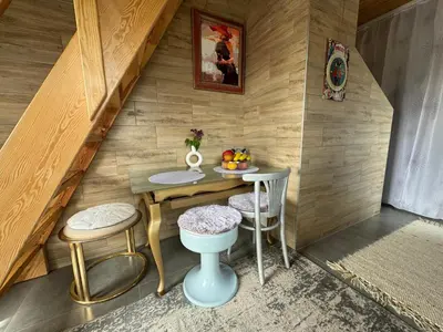 a small room with a table and two stools at Dvi liepos in Merkinė