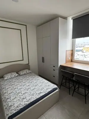 a bedroom with a bed and a desk next to a window at 16 Airport Apartment in Vilnius