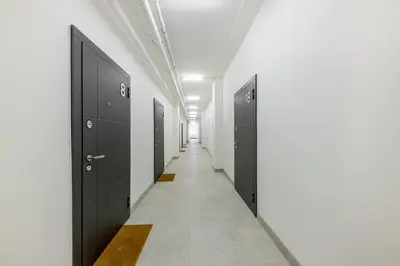 a corridor with black doors in a hallway at 16 Airport Apartment in Vilnius