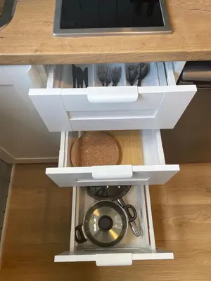 a drawer in a kitchen cabinet with a pot and utensils at Ignalinos Pliažo Klubas in Ignalina