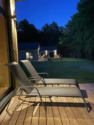 a pair of chairs sitting on a deck at night at Ignalinos Pliažo Klubas in Ignalina