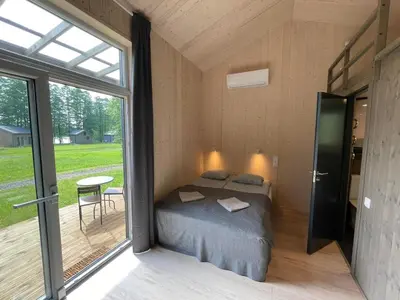 a bedroom in a house with a bed and a window at Ignalinos Pliažo Klubas in Ignalina
