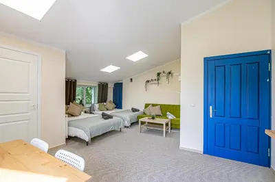 a living room with a couch and a blue door at The house Kaunas in Kaunas