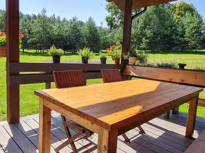 a wooden table and two chairs on a deck at Atostogų namelis-pirtis Prie upės in Anykščiai