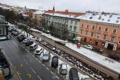 a city street filled with parked cars in the snow at Medieval Super Studio in Vilnius