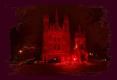 a lit up building with red lights in front of it at Medieval Super Studio in Vilnius