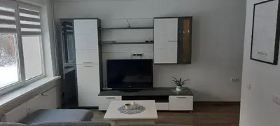 a living room with a tv and a couch and a table at Butukas in Anykščiai