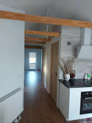 a kitchen with white counters and wooden ceilings at Apartments MILENA in Druskininkai