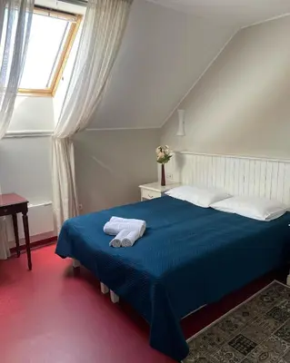 a bedroom with a blue bed and a window at A. Smetonos Dvaro Smetonienės svetainė in Lėnas
