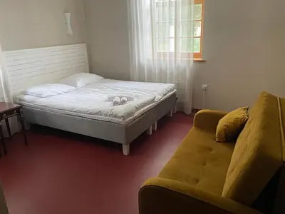 a small bedroom with a bed and a couch at A. Smetonos Dvaro Smetonienės svetainė in Lėnas