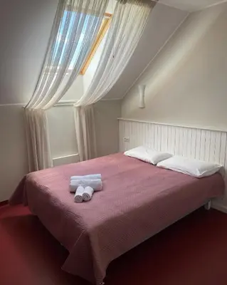 a bedroom with a large bed with two towels on it at A. Smetonos Dvaro Smetonienės svetainė in Lėnas