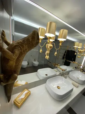 a bathroom with a sink and a toilet and a mirror at Luxury Queen V apartment with Jacuzzi in Kaunas