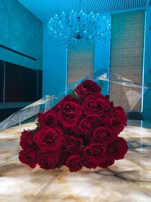 a bouquet of red roses in a blue room at Luxury Queen V apartment with Jacuzzi in Kaunas