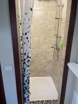 a bathroom with a shower with a shower curtain at Pušynas1 in Anykščiai