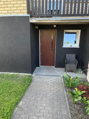 a door to a house with a chair in front of it at Pušynas1 in Anykščiai