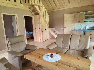 a living room with a couch and a table at Sodyba Žaliasis slėnis Anykščiuose in Anykščiai