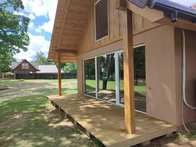 a front porch of a house with glass doors at Sodyba Žaliasis slėnis Anykščiuose in Anykščiai