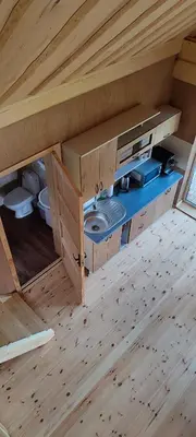 a room with a kitchen in a wooden house at Sodyba Žaliasis slėnis Anykščiuose in Anykščiai