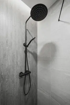 a shower with a shower head in a bathroom at Brand New Mindaugas Luxury Designer Apart in Vilnius