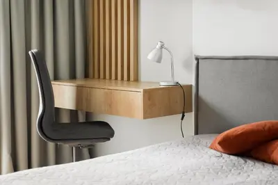 a bedroom with a desk and a chair next to a bed at Brand New Mindaugas Luxury Designer Apart in Vilnius