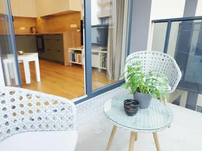 a white chair and a table with a potted plant at Brand New Mindaugas Luxury Designer Apart in Vilnius