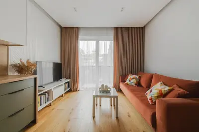 a living room with a couch and a table at Brand New Mindaugas Luxury Designer Apart in Vilnius