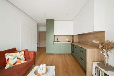 a living room with a couch and a kitchen at Brand New Mindaugas Luxury Designer Apart in Vilnius