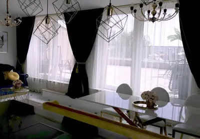 a dining room with a table and large windows at Luxury Penthouse with Large Terrace & Panoramic Old Town View in Vilnius