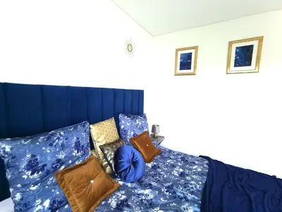 a bedroom with a bed with blue sheets and pillows at Luxury Penthouse with Large Terrace & Panoramic Old Town View in Vilnius