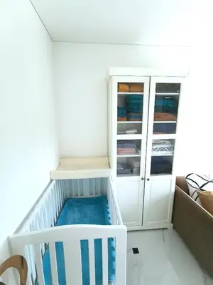a white crib in a room with a cabinet at Luxury Penthouse with Large Terrace & Panoramic Old Town View in Vilnius