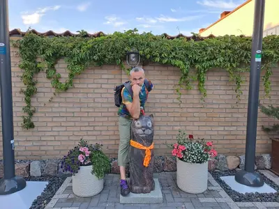 a man standing next to a statue of a cat at Vilnius Cat Friendly in Vilnius
