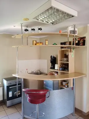 a kitchen with a counter and a red stool at Vilnius Cat Friendly in Vilnius