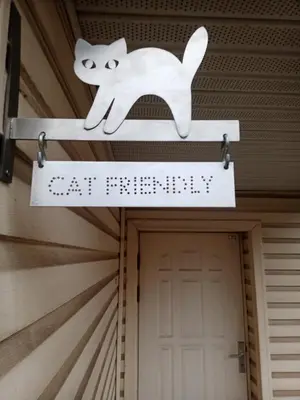 a cat sign hanging outside of a door at Vilnius Cat Friendly in Vilnius