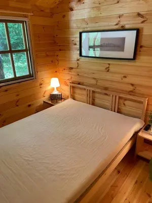 a bedroom with a bed and a tv on the wall at Vila Paradise Bay in Smalvos