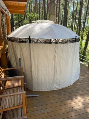 a large tent on a deck in the woods at Vila Paradise Bay in Smalvos