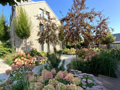 a garden with flowers in front of a building at Salt Garden Apartments in Druskininkai